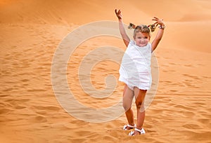 Little girl smiles and plays sand