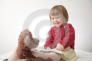 Little girl smiling happy. cute caucasian baby with bear and doll isolated on white background