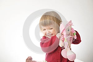 Little girl smiling happy. cute caucasian baby with bear and doll isolated on white background