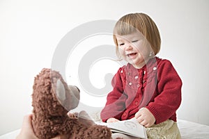 Little girl smiling happy. cute caucasian baby with bear and doll isolated on white background