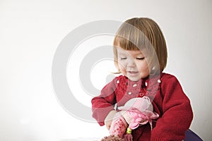 Little girl smiling happy. cute caucasian baby with bear and doll isolated on white background