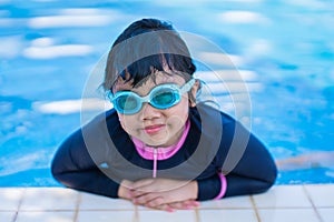 Little girl smiling wearing swimming glasses in swimming pool. children playing in swimming pool on summer