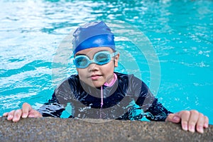 Little girl smiling wearing swimming glasses in swimming pool. children playing in swimming pool on summer