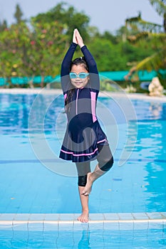 Little girl smiling wearing swimming glasses in swimming pool. children playing in swimming pool on summer