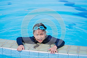 Little girl smiling wearing swimming glasses in swimming pool. children playing in swimming pool on summer