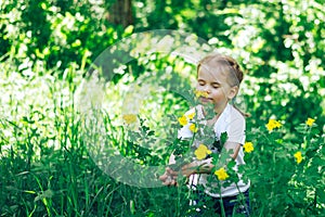 Little girl sniff the flowers in forest