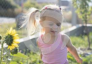 Little girl sniffing a sunflower