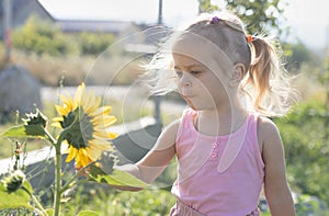 Little girl sniffing a sunflower