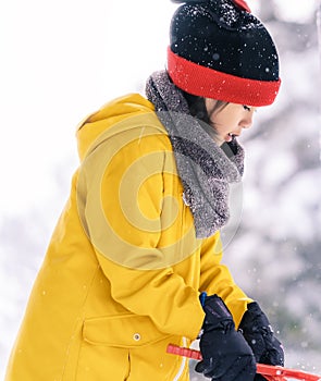Little girl in snow clothing playing with snow in a Skii resort photo