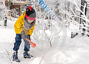 Little girl in snow clothing playing with snow in a Skii resort