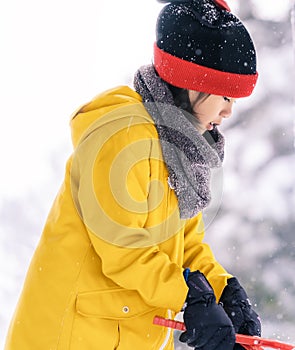 Little girl in snow clothing playing with snow in a Skii resort