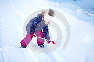 Little girl with a snow shovel.