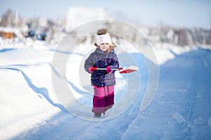 Little girl with a snow shovel.