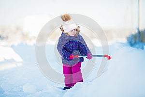 Little girl with a snow shovel.