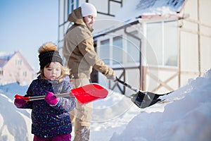 Little girl with a snow shovel.