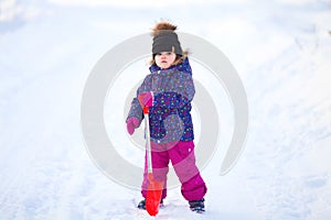 Little girl with a snow shovel.