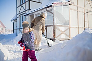 Little girl with a snow shovel.