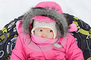 Little girl in snow tube. Winter tubing. Winter leisure activity concept. Family winter fun