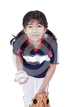Little girl in softball team uniform ready to throw a pitch