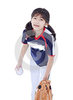 Little girl in softball team uniform ready to throw a pitch