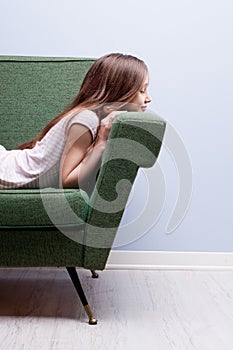 Little girl softly sleeping on a green sofa