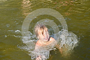 The little girl splashes in the water