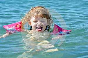 Little girl splashing in the crystal clear water in a lagoon