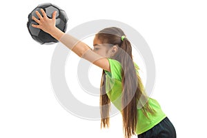 Little girl in sports uniform playing with soccer ball