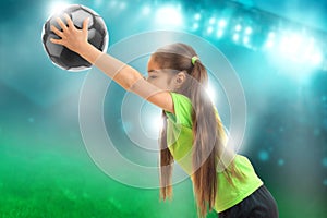 Little girl in sports uniform plays soccer