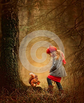 Little girl with squirrel  in an autumn forest