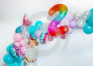 Little girl stand over birthday balloons decorations