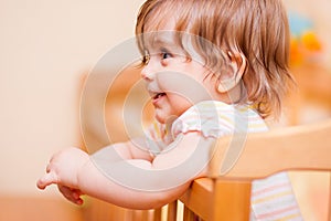 Little girl standing in the crib