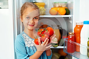 Little girl standing in front of a fridge and choosing food