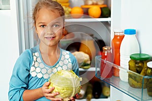 Little girl standing in front of a fridge and choosing food