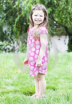 Little girl standing in grass