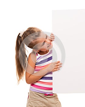 Little girl is standing on white background and holding white ca