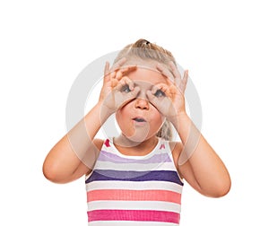 little girl standing on white background and pretending that holds the binoculars