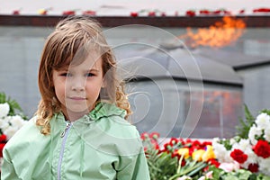 Little girl stands near memorial