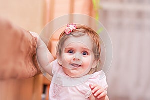 Little girl stands near the sofa at home.