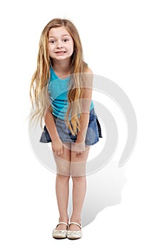 Little girl stands slightly bending forward photo