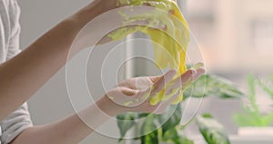 Little girl stretches yellow slime to the sides, hands close up stretching vibrant yellow slime, creative and fun