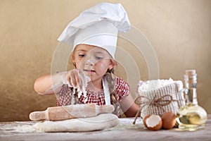Little girl stretching the cookie dough photo
