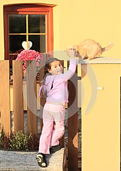 Little girl stroking cat