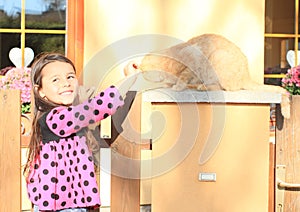 Little girl stroking a cat