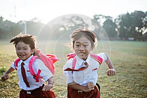 little girl student running together while going to their school