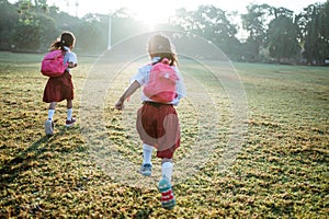 little girl student running together while going to their school