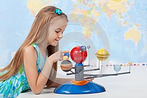 Little girl studies the solar system in geography class