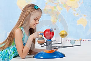 Little girl studies the solar system in geography class photo