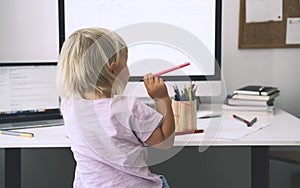 Little girl studying and drawing at desk