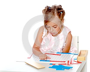 A little girl is studying Montessori stuff.